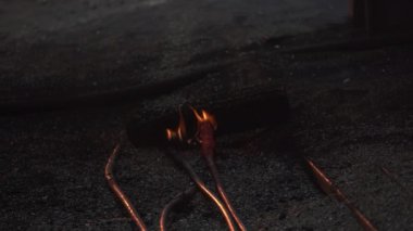 Hasarlı ve açığa çıkmış kablolar tutuşuyor, karanlık ve loş çevrede belirgin yangın tehlikeleri gösteriyor. Menkul Kıymetler