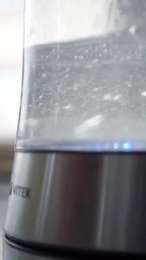 Mutfakta elektrikli cam çaydanlık var. Stok görüntüleri. Kabaran bir çaydanlığın yakın çekimi.