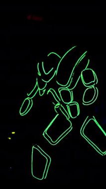 A man in the neon costume of cyborg is moving in the dark. Stock footage. Creativity and self expression concept, unusual costume with neon stripes.