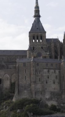 Mont Saint Michel, Normandiya Fransa, mimari konsepti. Ortaçağ manastırı dağda aynı isimde bulutlu gökyüzü arka planında.
