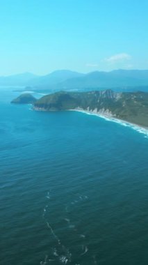 Zümrüt yeşili tarlanın ve mavi Japon denizinin havadan görünüşü. Şarjör. Mavi bulutlu gökyüzü ile yaz deniz manzarası