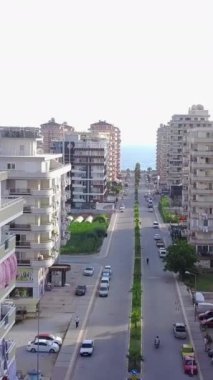 Denize çıkan şehir yolunun üst manzarası. Şarjör. Şehrin yüksek binalarının arasından geçen yol ufukta denize çıkar. Kasaba otellerinin deniz manzaralı düz yol manzarası.