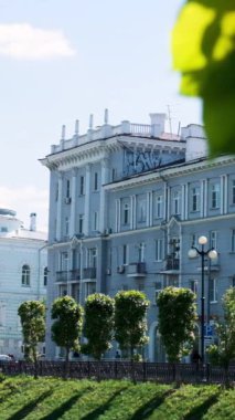 Şehrin merkez caddesinde güzel beyaz evler ve mavi bulutlu arka planda bir sürü yeşil ağaç var. Şehirde yaz, mimari konsepti.