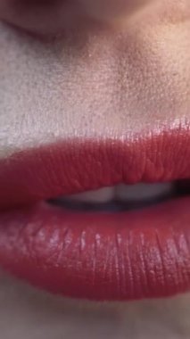 Yeşil zeytini ısıran bir kadının kırmızı seksi dudaklarına yakın çekim. Başla. Hassas kırmızı dudaklar, güzel ciltli genç bir kadının yüz detaylarına aşırı derecede yakın..