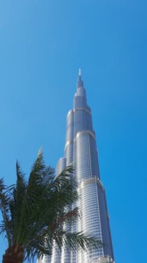 BAE 'deki Dubai AVM' de Burj Halife, ünlü bir simgedir. Başla. Gökdelen ve palmiye ağaçlarının alçak açılı görüntüsü