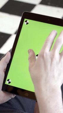 Tableti tutan ve yeşil ekrana dokunan adama yakın çekim. Hisse senedi. Genç serbest çalışan, çalışmak ya da proje yaratmak için tablet kullanır. Eklemek için yeşil ekranlı tablet.
