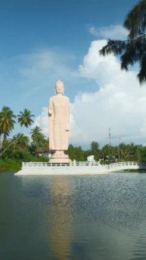 Tsunami Honganji Vihara, Hikkaduwa, Sri Lanka. Başla. Yeşil palmiye ağaçları ve mavi bulutlu gökyüzü arasında güzel beyaz heykel