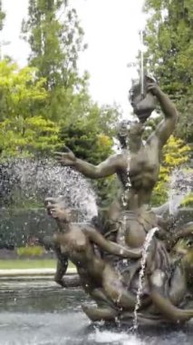 Park 'ta heykelleri olan eski güzel bir çeşme. Başla. Yeşil Park 'ın arka planındaki çeşmede deniz kızları olan heykel kompozisyonu.