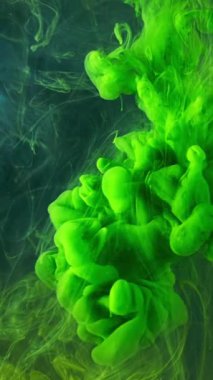 Koyu mavi parlak suda akrilik mürekkebin güzel bir karışımı. Stok görüntüleri. Suyla karışırken yeşil mürekkep akışını kapat ve inanılmaz bir bulut oluştur..