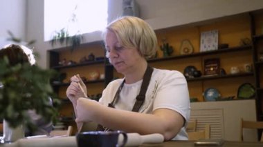 Canlı ve davetkar bir atölyede, bir sanatçı ustalıkla yaratıcı enerjiyle dolu çarpıcı bir eser yaratır. Menkul Kıymetler