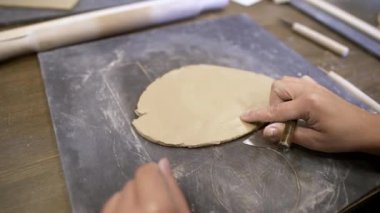 Becerikli eller, çalışma alanındaki aletleri kullanarak, eşsiz çömlek tekniklerini sergileyerek yumuşak çamuru sanata dönüştürür. Menkul Kıymetler