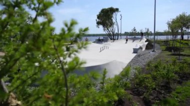 Parlak ve canlı bir kaykay sahnesi. Kaykaycıların güneşli bir günün tadını çıkardıkları bir yer. Kırp