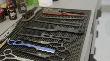 Makas, tarak ve diğer temel gereksinimleri içeren Wellorganize saç kesme araçları bir çalışma yüzeyi üzerinde serilmiştir. Kırp