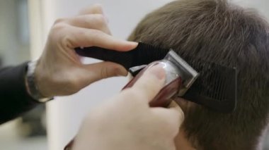 Çağdaş bir kuaför ortamında, yetenekli bir berber hem kırpıcı hem de sanatsal stil müşterilerinin saçını tarar. Kırp