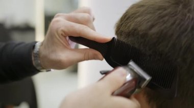 Şık bir kuaförde, yetenekli bir berber, modern bir kırpıcı ile müşterinin saçını, kusursuz ve rahat bir kesim için keser. Kırp