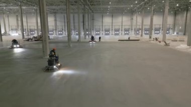Kendini işine adamış işçiler geniş bir depo ortamında geniş beton zemini titizlikle cilalayarak kaliteyi sağlıyorlar. Kırp
