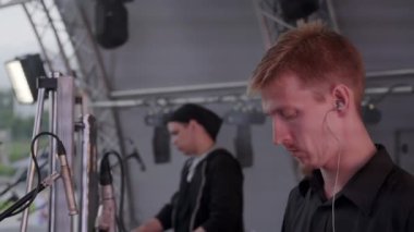 Gürcistan, Tiflis - 20 Temmuz 2024: Profesyonelce hazırlanmış heyecan verici bir açık hava etkinliğinde iki yetenekli müzisyen canlı performans sergiliyor. Kırp