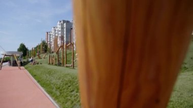 Gürcistan, Tiflis - 17 Haziran 2024: Arka planda modern yerleşim binaları olan çocuklar için bir dizi oyun yapısının sergilendiği bir şehir parkı. Kırp