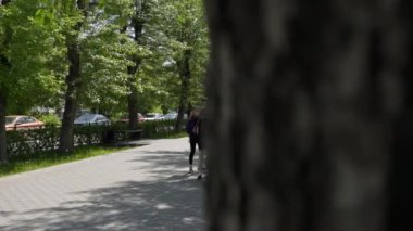 Gürcistan, Tiflis - 17 Haziran 2024: Bereketli, yeşil ağaçlar ve boş yürüyüşler için asfalt bir yol gösteren güzel, sakin bir park. Kırp