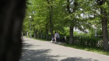 Gürcistan, Tiflis - 17 Haziran 2024: İki kişi, doğanın güzelliğiyle çevrili sakin yeşil bir parkta huzurlu bir günün tadını çıkarıyorlar. Kırp