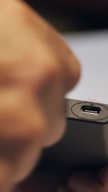 Taşınabilir güç bankasına USB kablo şarj cihazı yerleştiriyorum. Bir adamın eli, şarj aletine kablo yerleştirirken yakın çekim..