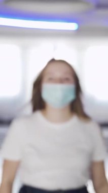 Maskeli kadın AVM 'de sıcaklığı kontrol ediliyor. Medya. Sinema ve alışveriş merkezlerini ziyaret edenler temas olmayan termometre kullanılarak sıcaklık için kontrol edilirler..