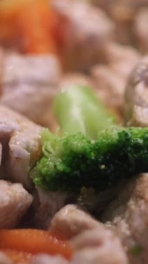 Kızarmış tavuğu sebzeyle, sağlıklı yemek ve diyetle karıştır. Kızgın ayçiçeği yağında kızarmış yeşil brokoli, havuç ve tavuğa yakın durun..