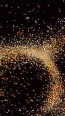 Milyonlarca renkli kum tanesinin uçuşup daireler oluşturduğu soyut dönen desen. Animasyon. Işıldayan yüzey, rüzgarın her bir dalgasını sürekli değişen formlarda açığa çıkarıyor.