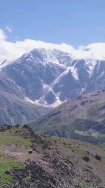 Yazın dağların arka planındaki gözlemevinin en iyi manzarası. Şarjör. Dağların ortasında kar zirveleri olan bir araştırma istasyonu..