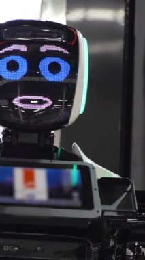 Elektronik suratlı gelecekçi robot. Medya. Yüzünde şirin bir ifade olan komik konuşan robot. Gelecekteki yeni teknolojilerin sergilendiği gelecekçi robotlar.