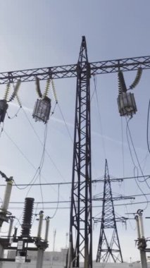 Mavi gökyüzü arka planındaki elektrik hatlarının alt görüntüsü. Başla. Yüksek voltajlı elektrik hattı şehirlere elektrik sağlıyor.