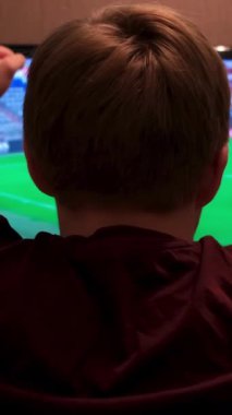 Spor, mutluluk ve insan konsepti, TV 'de spor izleyen ve evdeki takımı destekleyen adam. Bir adamın oturduğu ve maç izlediği, yumruklarını kaldırdığı ve el çırptığı sahne..