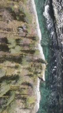 Yazın yeşil orman ve taşların arasından akan mavi soğuk bir nehrin havadan görünüşü. Şarjör. Taştan akarsu ve ağaçlarla dolu doğa manzarası