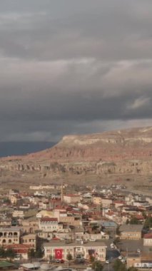 Güneşli bir yaz gününde güneşli bir güney şehrinin havadan panoramik görüntüsü. Başla. Arka plandaki kuru dağlarda birçok küçük ev ve dar sokaklar
