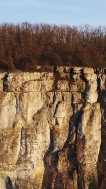 Tepesinde kaya uçurumu ve Hristiyan haçı olan panoramik bir manzara. Vuruldu. Din kavramı, inanç ve barış yeri, dağ ve haç manzarası.