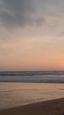 Sakin denizi ve batan güneşi olan güzel bir deniz manzarası. Başla. Kumlu sahilde güzel bir gün batımı. Kumsalda sakin dalgalar ve ufukta batan güneş.