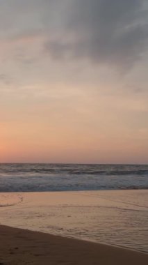 Sakin denizi ve batan güneşi olan güzel bir deniz manzarası. Başla. Kumlu sahilde güzel bir gün batımı. Kumsalda sakin dalgalar ve ufukta batan güneş.