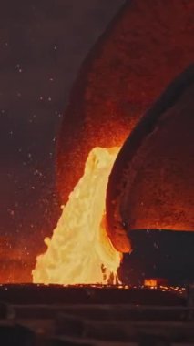 Çukur kalıplara sıvı metal döker. Stok görüntüleri. Çukurdan erimiş metal sıvısı dökülüyor. Metalurjik santralde sıvı metal akışı kalıplara dökülür..