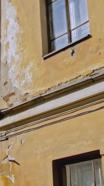 Eski apartman cephesinde aşınmış alçı var. Stok görüntüleri. Güneşli bir günde eski apartman binası