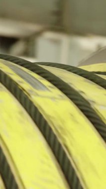 Sarılmış sarı lastik hortumlar sergileniyor, ekipmanlarla dolu bir endüstriyel depo düzeneği sergileniyor. Menkul Kıymetler
