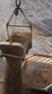 Bir kazıcı ve bir damperli kamyon büyük ölçekli bir madencilik operasyonunda birlikte çalışıyorlar. Menkul Kıymetler