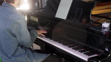 Yetenekli bir müzisyen tutkulu bir şekilde kuyruklu piyano çalar, yaratıcı anları canlı doğal ışıkta yakalar. Kırp