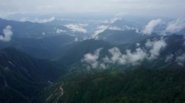 Canlı yemyeşil ve sürüklenen bulutlarla çevrili sisli dağların nefes kesici ve çarpıcı görüntüsü. Menkul Kıymetler