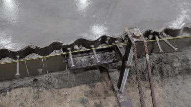 Detaylı bir bakış açısı, beton levhanın özel aletler ve ekipmanlarla dikkatlice bitirildiğini gösteriyor. Kırp