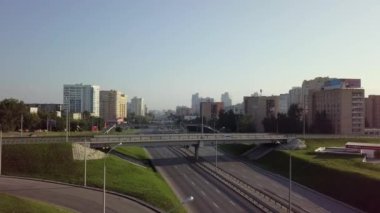 Canlı bir şehir silueti, modern mimari ve bol yeşil alanlar sergilenen bir otoyola sahiptir. Menkul Kıymetler