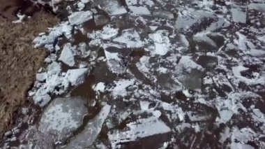 Donmuş suyun insansız hava aracı görüntüsü karmaşık buz kalıpları ve sakin kış manzarasındaki dokuları gösteriyor. Menkul Kıymetler