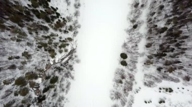 Karla kaplı bir nehir ve sık yeşil ağaçlarla nefes kesici bir kış harikalar diyarının çarpıcı hava manzarası. Menkul Kıymetler