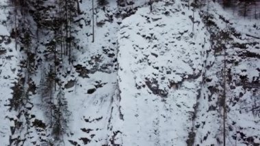 Karla kaplı kayalık dağ manzarası, sonsuz yeşil ağaçlar, dingin kış vahşi doğası ve doğal güzelliği gözler önüne seriyor. Menkul Kıymetler