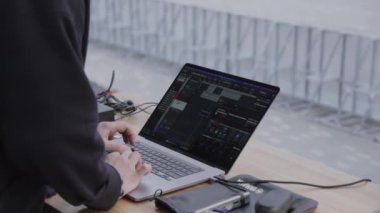 Gelişmiş ses donanımına bağlı yüksek performanslı bir dizüstü bilgisayar, modern bir müzik prodüksiyonu kurulumunu gösteriyor. Kırp