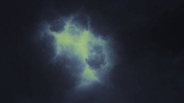 Büyüleyici ve büyüleyici bir görüntü sergiliyor. Karanlık bulutlar çarpıcı bir şekilde diğer dünyaların ışıltısıyla aydınlanıyor.